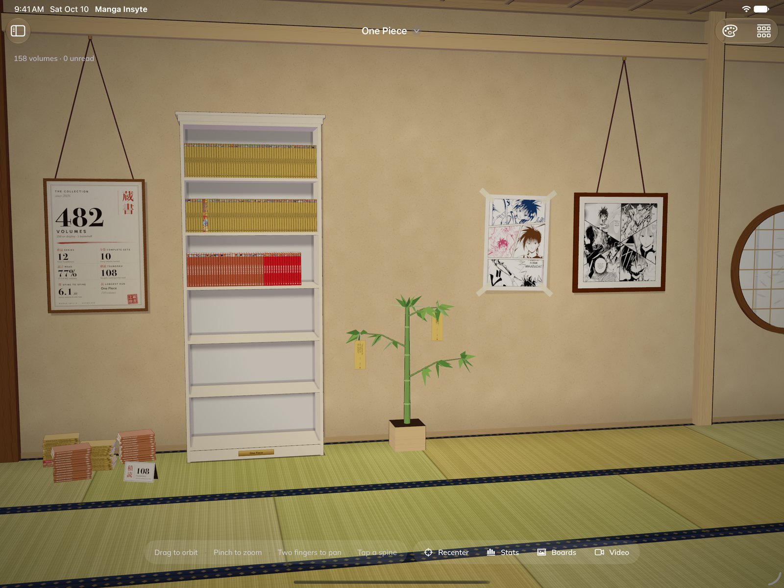 The Showcase on iPad: a Japanese room with the One Piece bookcase, a collection poster, framed boards, a bamboo hung with quotes and a pile of unread volumes on the tatami